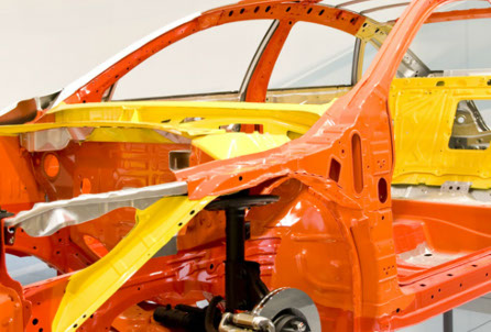 Vehicle body shell in orange and yellow primer during repair